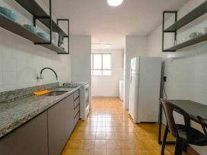 a kitchen with a refrigerator and a table with chairs at Apartamento Funcional Melhor Maringá! - SQ33 in Maringá +7 photos