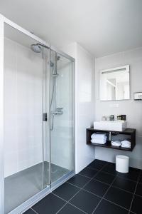 a bathroom with a glass shower and a sink at Hotel de Flore - Montmartre in Paris