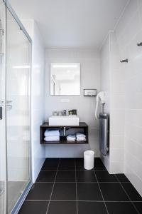 bagno bianco con lavandino e doccia di Hotel de Flore - Montmartre a Parigi