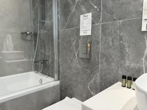 a bathroom with a shower and a toilet and a sink at Phaedrus Living: White Hills Suites City View in Aglantzia
