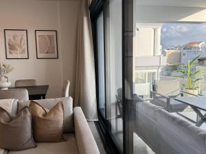 a living room with a couch and a large window at Phaedrus Living: White Hills Suites City View in Aglantzia