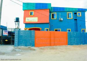 a colorful building with a fence in front of it at Elios Hotels in Ughelli
