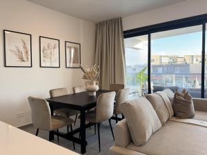salon ze stołem i kanapą w obiekcie Phaedrus Living: White Hills Suites City View w mieście Aglantzia