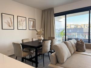 a living room with a table and a couch at Phaedrus Living: White Hills Suites City View in Aglantzia