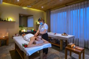 a woman in a room with two beds and a nurse at Sarangkot Mountain Lodge in Pokhara