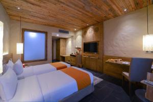 A bed or beds in a room at Sarangkot Mountain Lodge