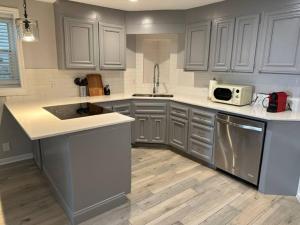 a kitchen with gray cabinets and a sink and a microwave at Elegant 1 Bdr-Montrose_ Siena @The Italian Plaza in Houston