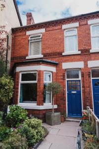 a red brick house with a blue door at Hoole House in Chester