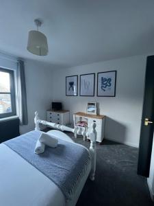 een witte slaapkamer met een bed en een tafel bij Nevis Croft Apartment 2 in Fort William