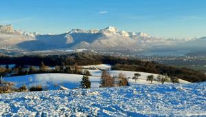 a snow covered hill with mountains in the background at Charmant chalet 8p calme et vue sur montagnes in Verchères