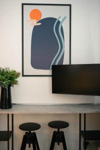 a table with two stools in front of a television at Black Marble - Design Apartment in Bari