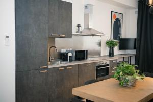 a kitchen with wooden cabinets and a wooden table at Black Marble - Design Apartment in Bari +17 photos