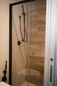 a shower with a glass door in a bathroom at Black Marble - Design Apartment in Bari