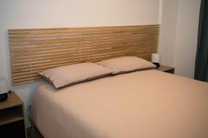 a bedroom with a bed with a wooden headboard at Black Marble - Design Apartment in Bari