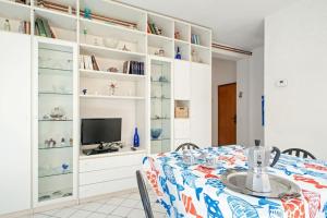 comedor con mesa y TV en Cozy Apartment 2minutes from the beach, en Cecina