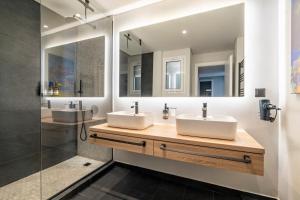 two sinks in a bathroom with two mirrors at Luxury 2BR Penthouse with City Skyline Terrace, near Kolonaki in Athens