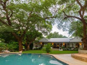 a house with a swimming pool in front of a house at The Courtney Lodge in Victoria Falls