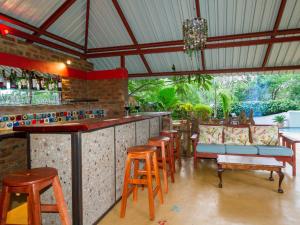 un bar con taburetes de madera y una barra con sillas en The Courtney Lodge en Victoria Falls
