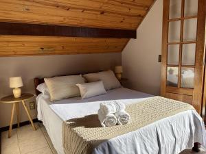 a bedroom with a bed with towels on it at Pousada Flor de Lua Monte Verde in Monte Verde