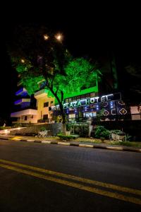 a building with a green sign on the side of a street at Rovi Plaza Hotel in Serra Negra