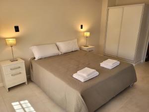 Deán FunesBelgrano Apart的一间卧室，床上有两条毛巾