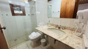 uma casa de banho com um lavatório, um WC e um chuveiro em Pousada Flor de Lua Monte Verde em Monte Verde