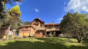 a large house with a yard at Pousada Flor de Lua Monte Verde in Monte Verde