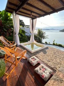 a patio with a fountain and chairs on a deck at Oásis Beach House in Angra dos Reis