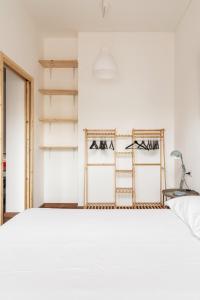 a bedroom with a white bed and shelves at AirLoft 3 confort vicino a Rho Fiera in Rho