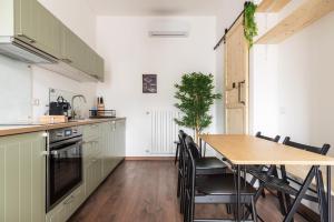 a kitchen with a wooden table and a dining room at AirLoft 3 confort vicino a Rho Fiera in Rho