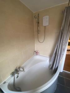 a white bath tub in a bathroom with a shower at 2bed apartment free parking in Oxford