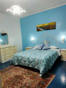 a bedroom with a bed with a blue wall at Villa Sartori in Legnago