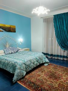 a blue bedroom with a bed and a rug at Villa Sartori in Legnago