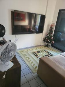 Habitación con ventilador y árbol de Navidad en el suelo en Apartamento 3 quartos beira mar Intermares-Cabedelo VALOR DA TAXA DE LIMPEZA E DO AR CONDICIONADO COBRADO À PARTE, en Cabedelo