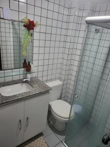 a bathroom with a toilet and a sink and a mirror at Apartamento 3 quartos beira mar Intermares-Cabedelo VALOR DA TAXA DE LIMPEZA E DO AR CONDICIONADO COBRADO À PARTE in Cabedelo