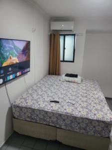 um quarto com uma cama e uma televisão de ecrã plano em Apartamento 3 quartos beira mar Intermares-Cabedelo VALOR DA TAXA DE LIMPEZA E DO AR CONDICIONADO COBRADO À PARTE em Cabedelo