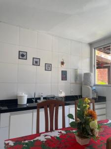 a kitchen with a table and chairs and a counter top at Porto dos Lençóis, Apartamento 05 in Barreirinhas