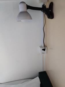 a lamp hanging on a wall next to a bed at Santa Catarina Hostel in Florianópolis