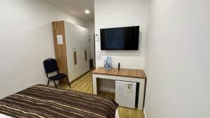 sypialnia z łóżkiem i telewizorem na ścianie w obiekcie Sulimen Camp w mieście Tengiz