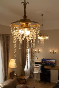 una lámpara de araña colgada del techo en la sala de estar en Beautiful, spacious apartment! Free Private Parking, en Riga