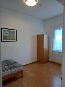 ein leeres Zimmer mit einem Bett und einem Schrank in der Unterkunft Schöne Ferienwohnung in Gernsbach in Gernsbach