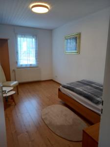 Schlafzimmer mit einem Bett, einem Fenster und einem Teppich in der Unterkunft Schöne Ferienwohnung in Gernsbach in Gernsbach