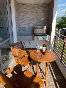 uma mesa com uma garrafa de vinho e 2 cadeiras numa varanda em apartamento en peñazul aldea em Ricaurte