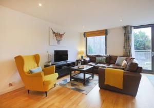 a living room with a couch and a tv at The East London Residence in Edinburgh
