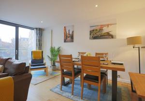 sala de estar con mesa, sillas y sofá en The East London Residence, en Edimburgo