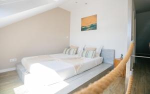 a white bedroom with a bed and a couch at Lapoint Surf Camp Ericeira in Ericeira
