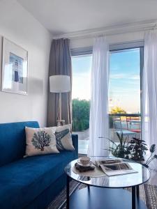 sala de estar con sofá azul y mesa de cristal en Spacious Three-Bedroom Apartment with Sea View A4, en Lapithos