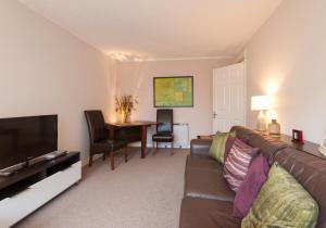 ein Wohnzimmer mit einem Sofa und einem Tisch in der Unterkunft Logie Green Road Apartment in Edinburgh