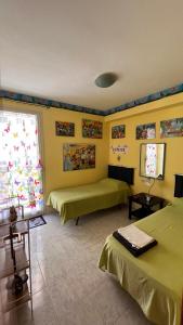 カヴァ・ダリーガにあるCava's Homeの緑のベッド2台と窓が備わる客室です。