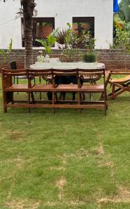 a picnic table with a cat sitting under it at Little Things Earth - Pine villa in Auroville